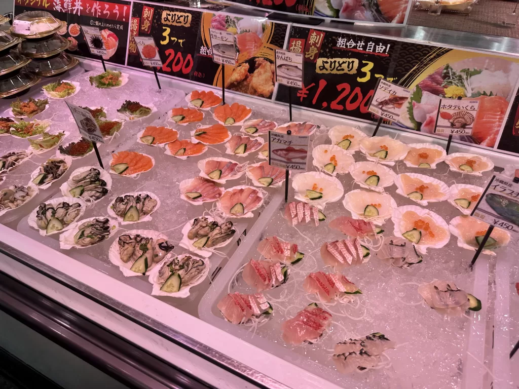 Sashimi counter with price signs: any three plates for 1200 yen