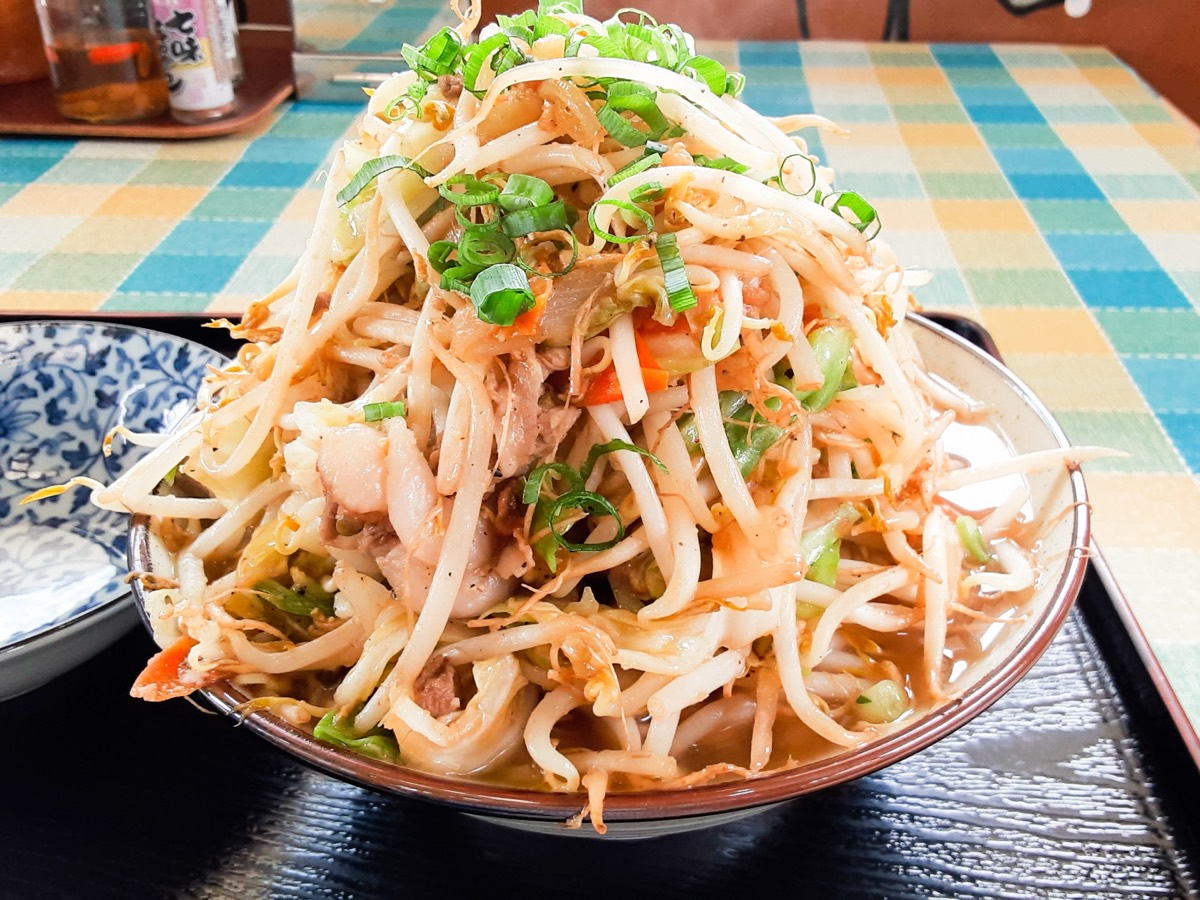 A bowl of Okinawa soba piled high with bean sprouts and pork