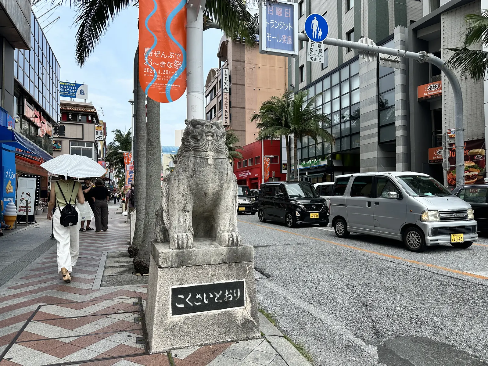 A stone shisa on its plinth at the entrance to Kokusai-dori in Naha
