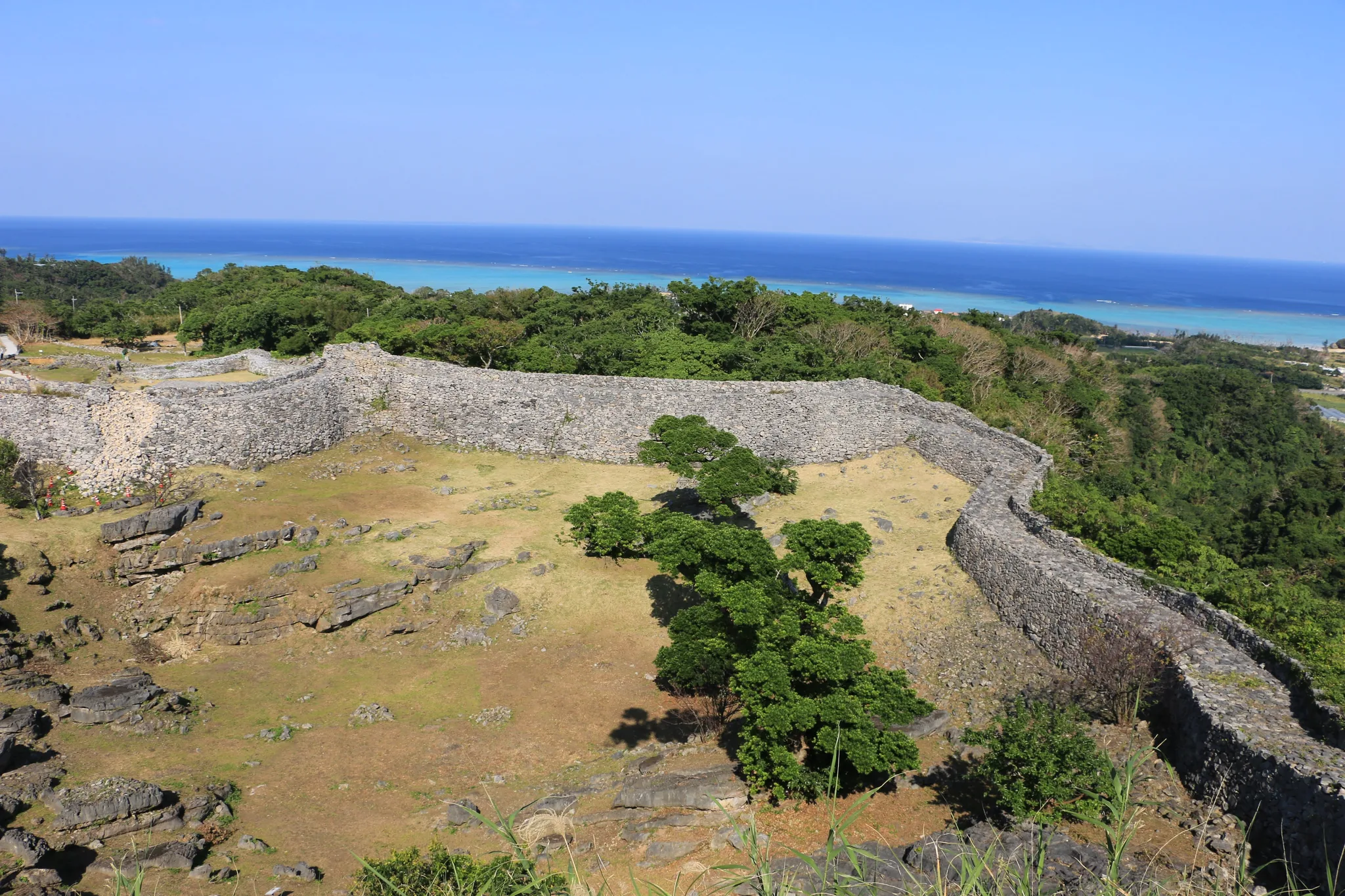The curved stone walls of Nakijin Castle above the sea