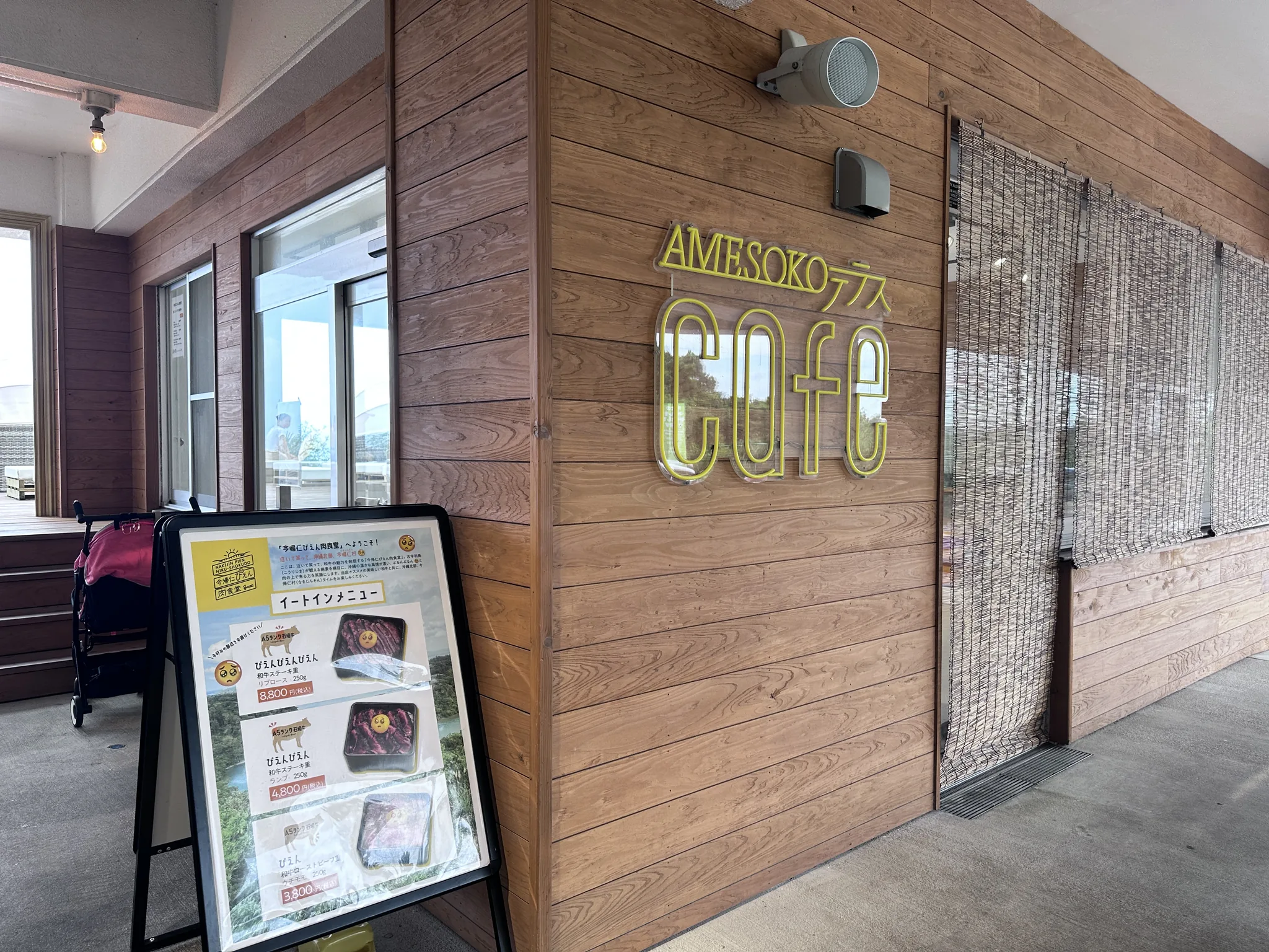 Rikarika Warumi 的 AMESOKO 露臺咖啡與門口的菜單看板
