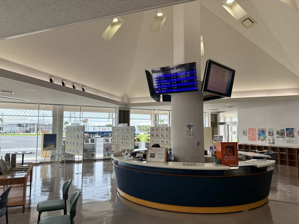 A live Naha Airport departures monitor inside the Toyosaki information station, with a free Wi-Fi sign