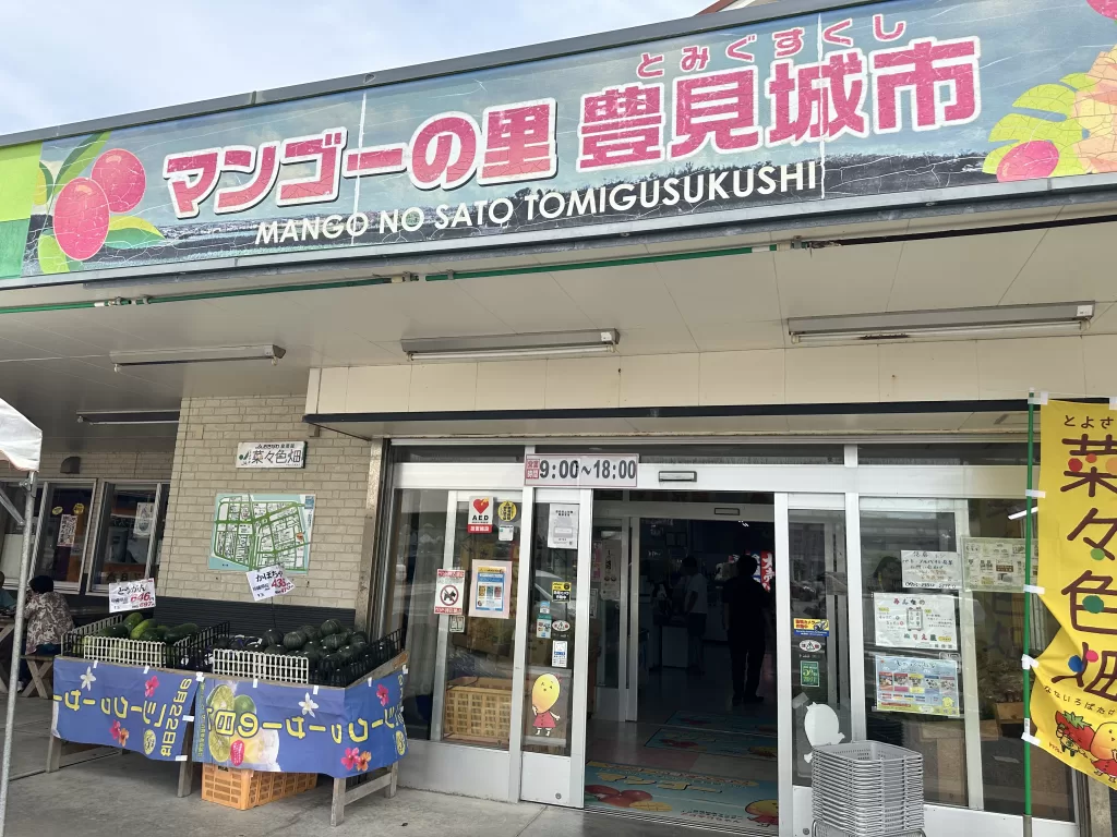 The Nanairo-batake market entrance with a large Mango no Sato Tomigusuku sign