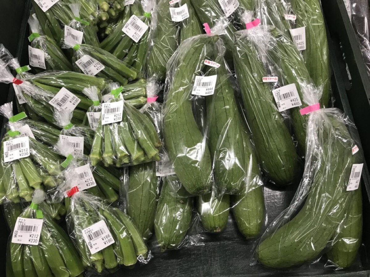 Bagged okra and sponge gourd with grower name tags at Uru Marche