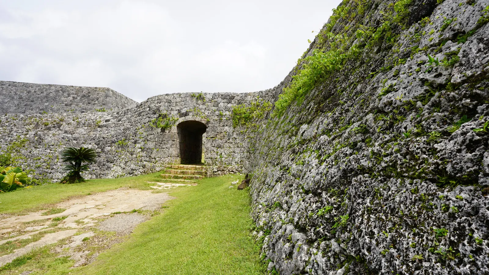 An arch gate set into the curving wall of Zakimi Castle