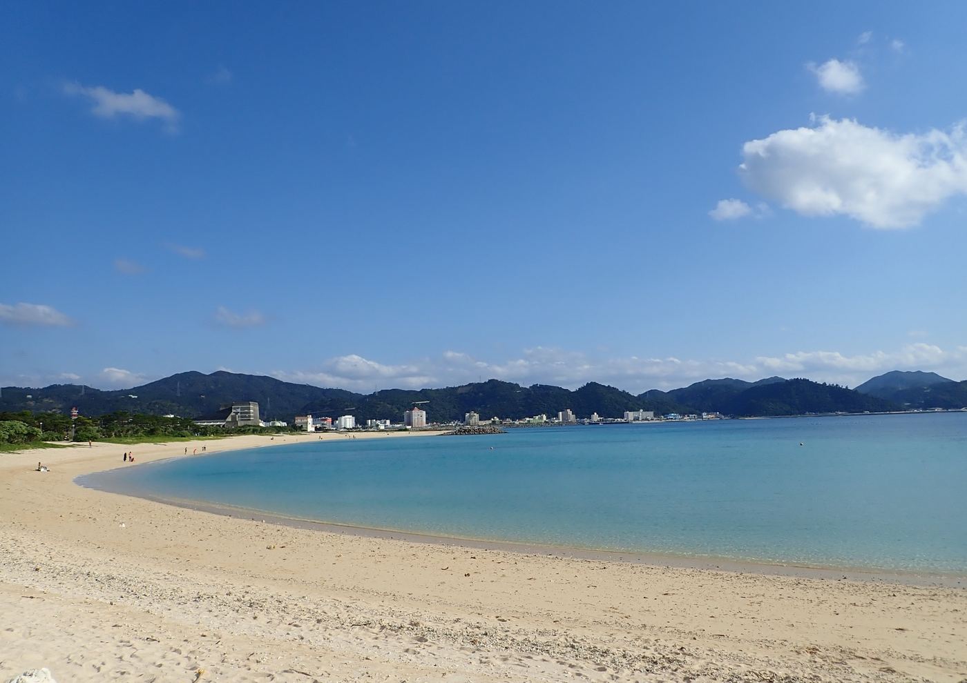 21世紀の森ビーチの砂浜と名護湾、その先の街並み