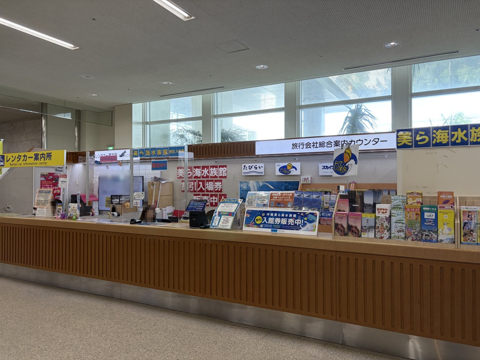 旅行会社総合案内カウンター。美ら海水族館の入場券販売の表示がある