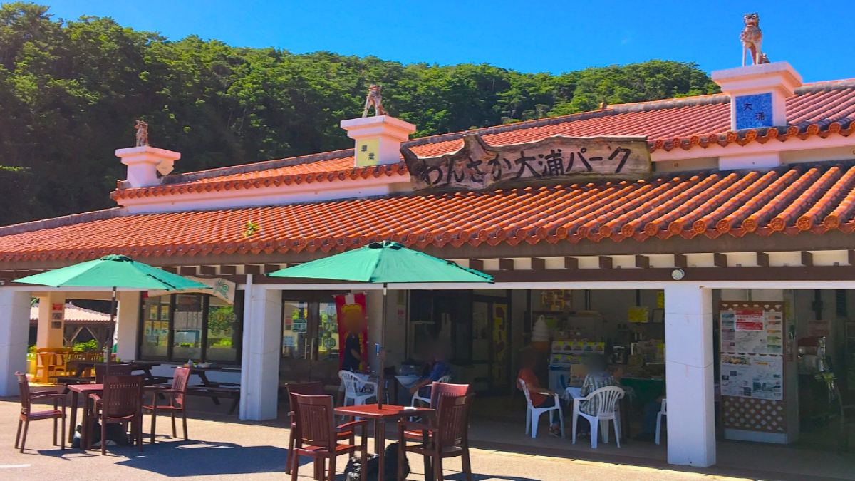 わんさか大浦パークの建物。赤瓦の屋根とテラス席のパラソル