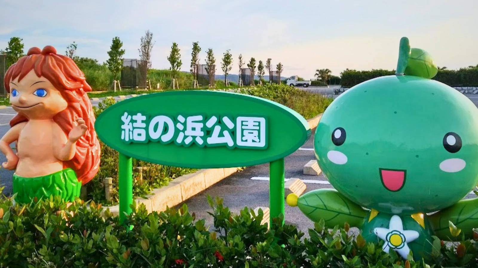 結の浜公園の入口の看板と、大宜味村のキャラクター「ぶながや」の像